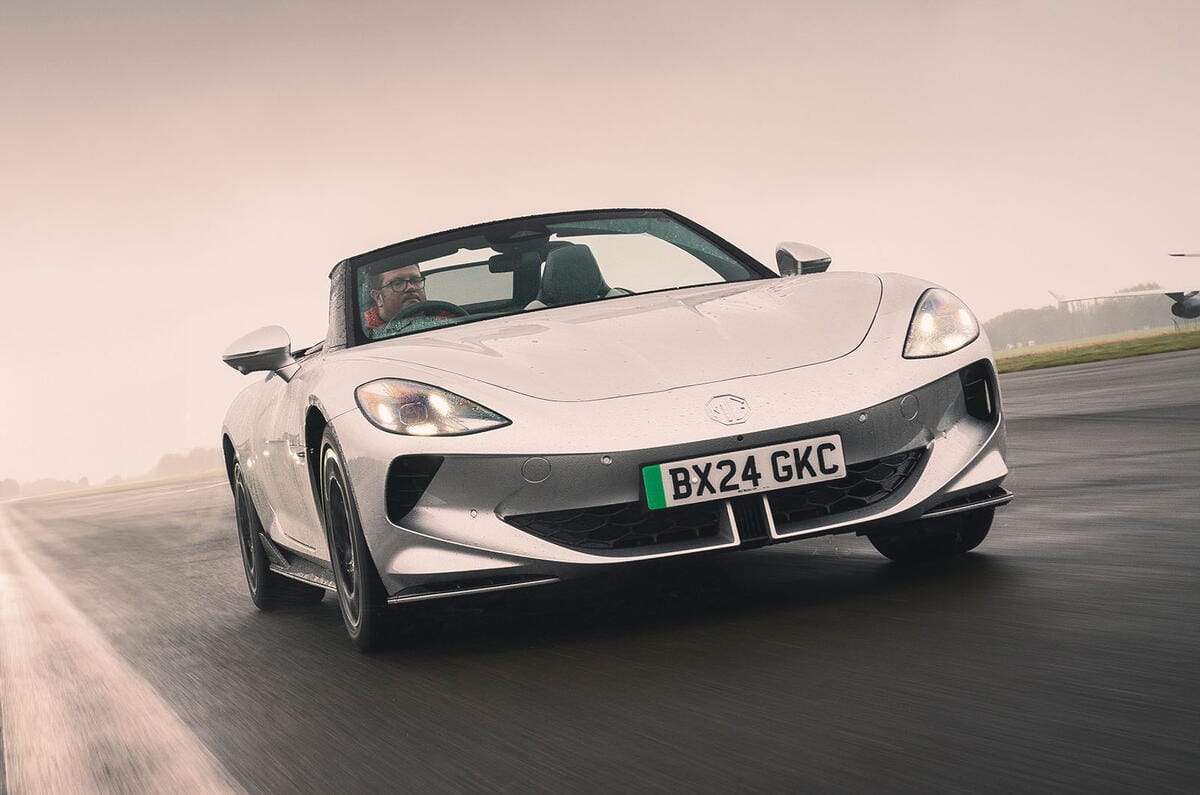 ام جی سایبرستر ۲۰۲۵ در جاده با درهای قیچی شکل باز نمای جلو ام جی سایبرستر در حال حرکت با سقف باز